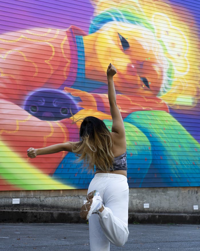 content creator in front of vancouver mural